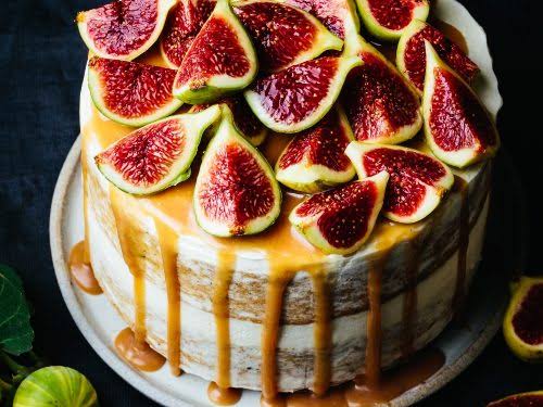 Rustic layer cake topped with halved roasted figs and honey drizzle