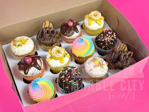 A dozen confetti cupcakes with swirled vanilla buttercream and sprinkles